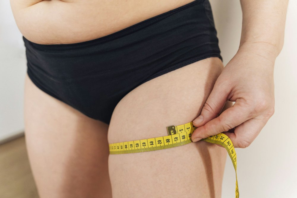 woman measuring thigh