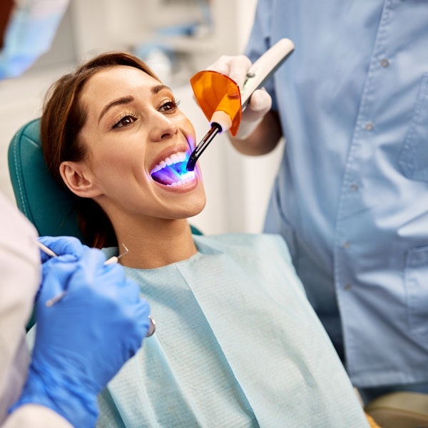 dentist using blue light to set bonding agent
