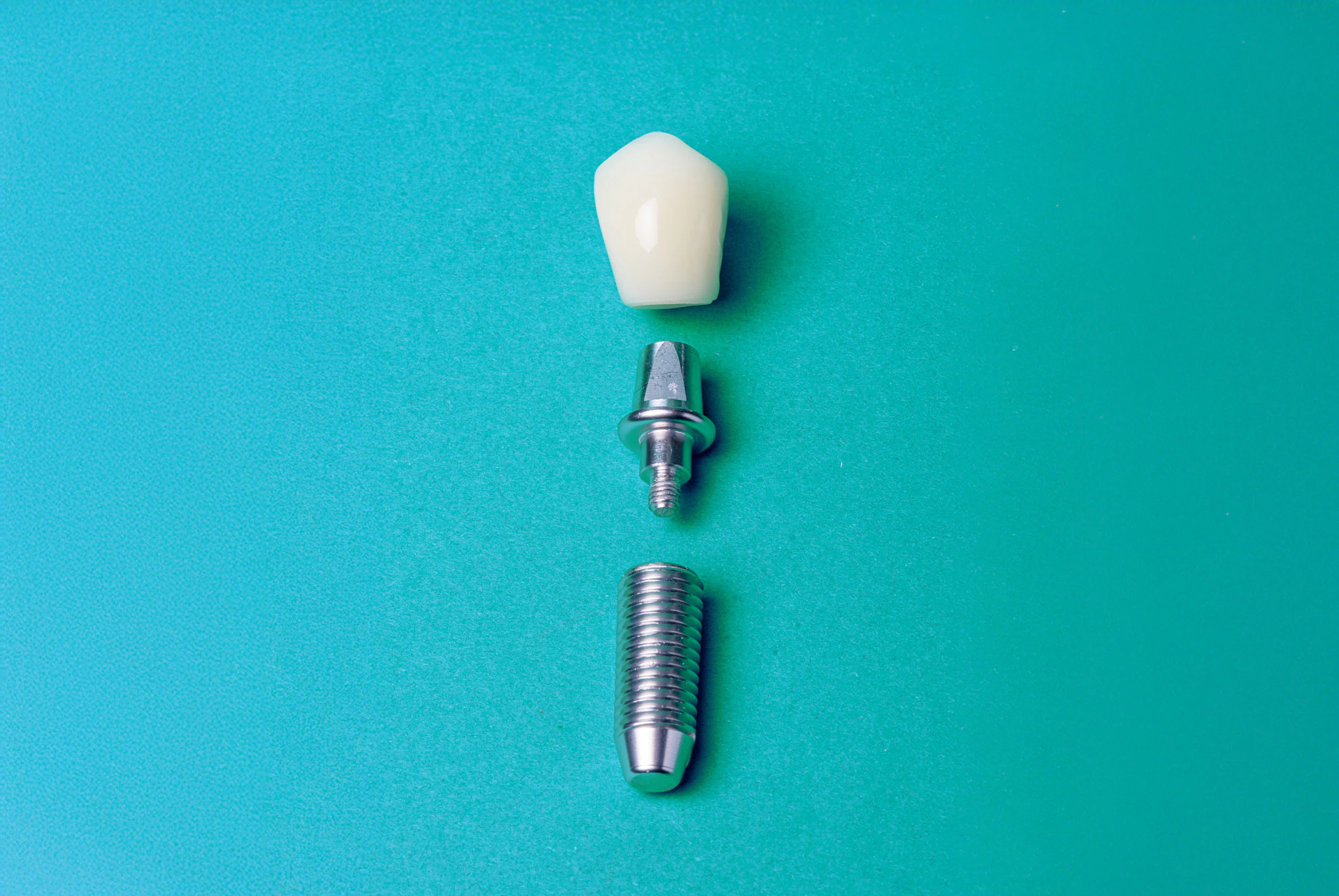 close up photo of a dental implant on a teal background