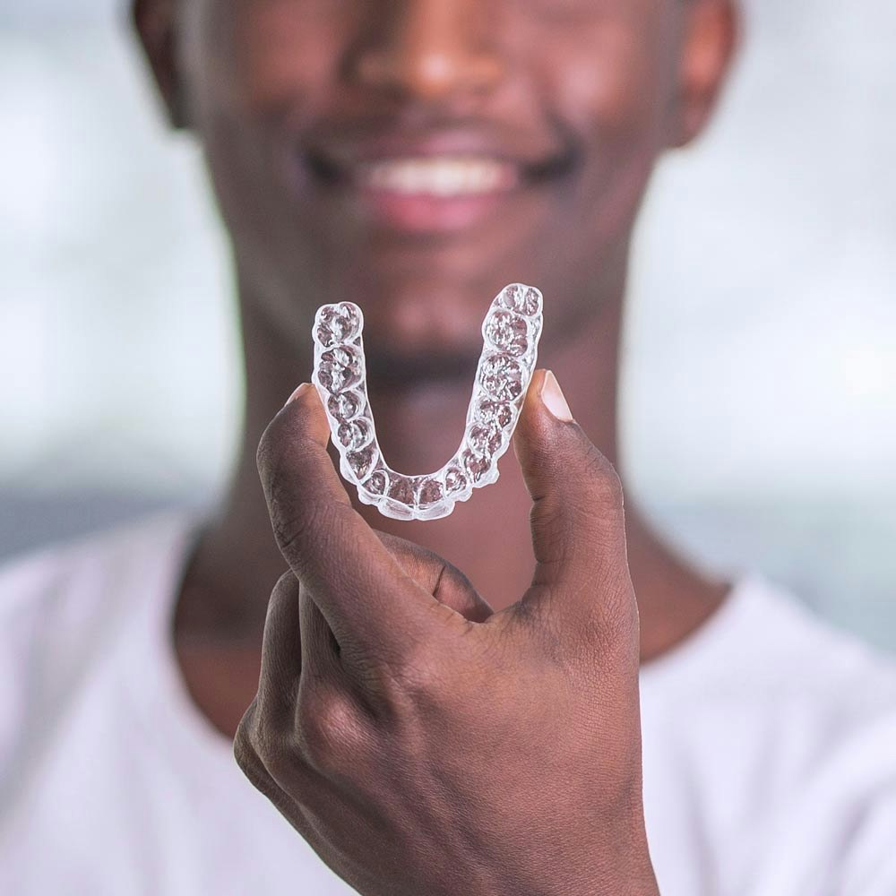 Man holding clear aligner tray