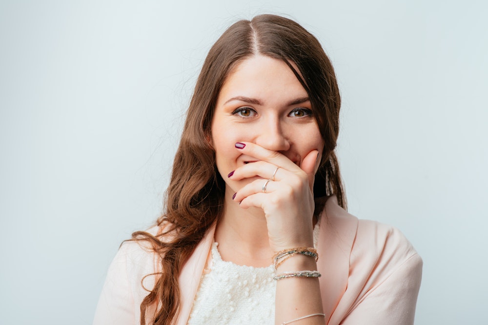 Girl covering her smile
