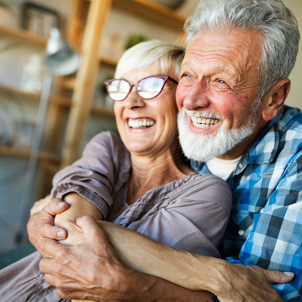 Happy older couple embracing at home