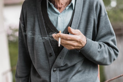 Elderly hands holding a cigarette
