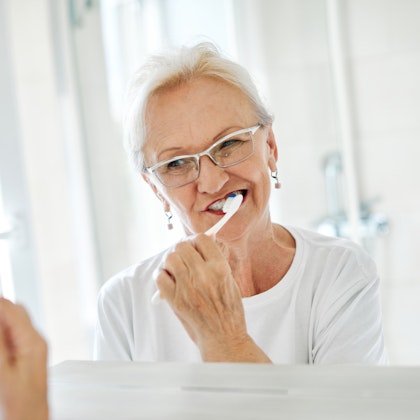 Mature woman brushing her teeth