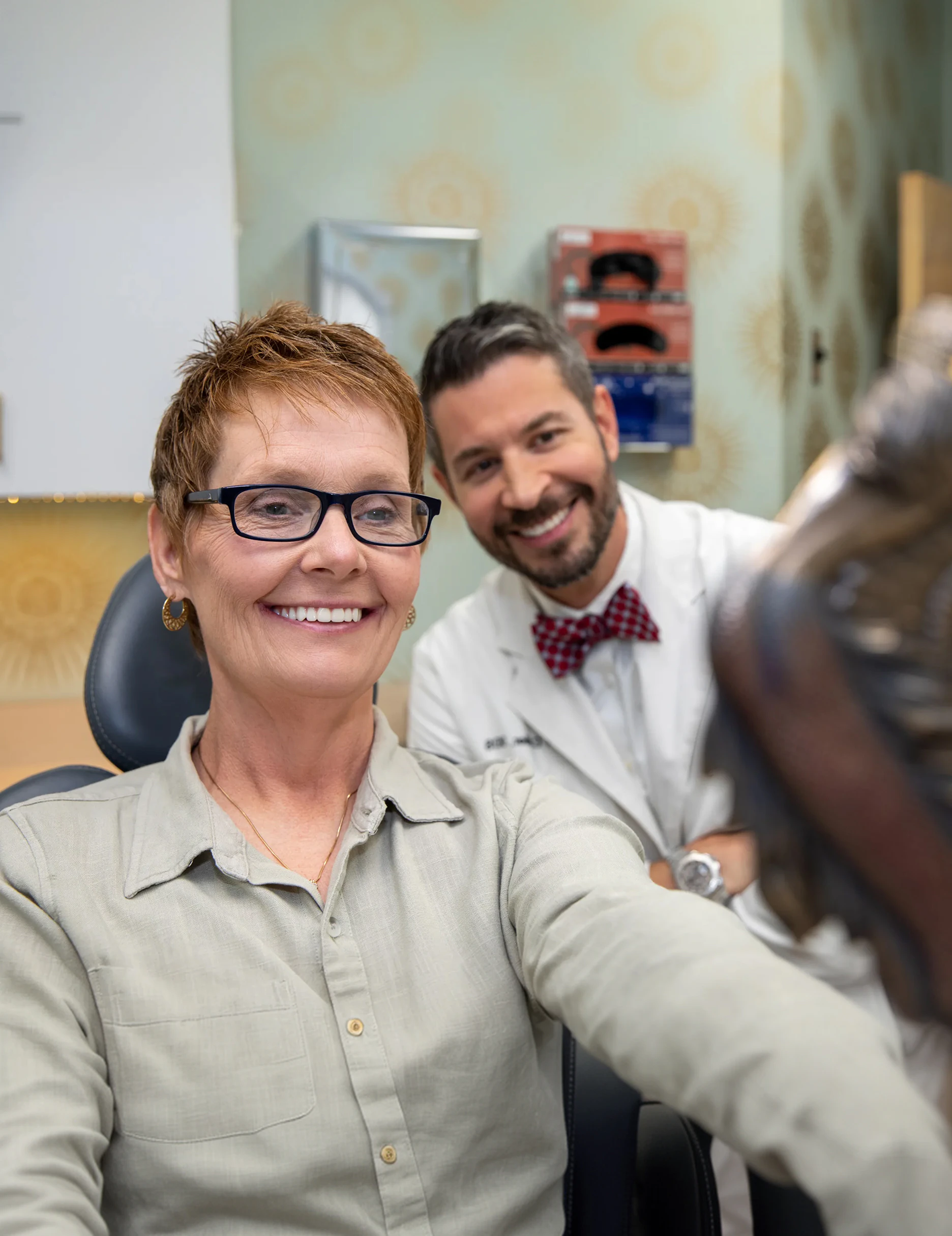 real patient smiling with dr. collier in the backgorund