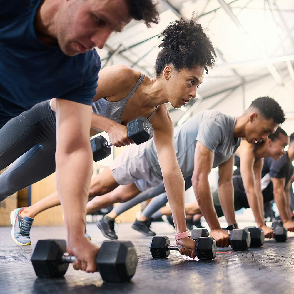 people exercising in a gym, focus on a woman.