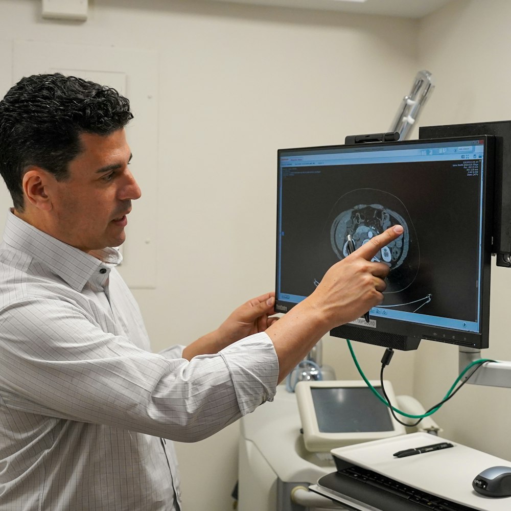 Dr. Oren Lerman reviewing CT scan on monitor in clinical exam room