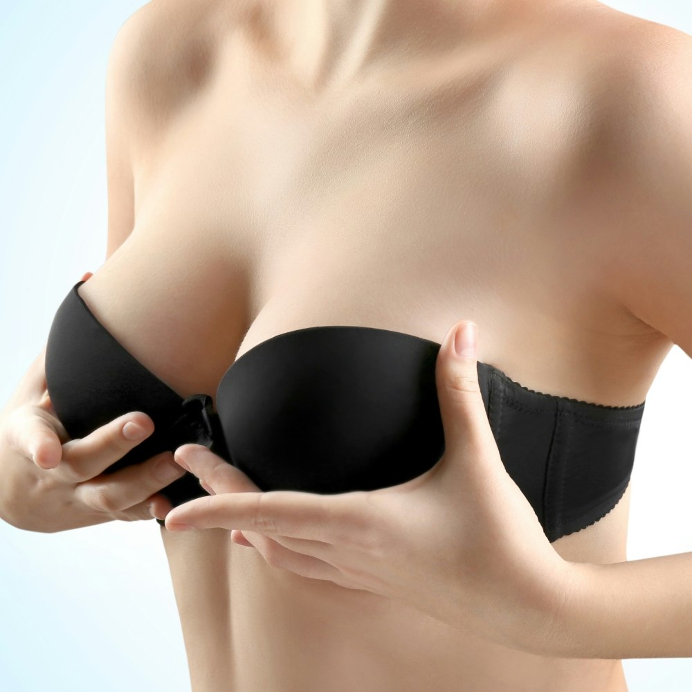 A woman holding up her breasts with her hands