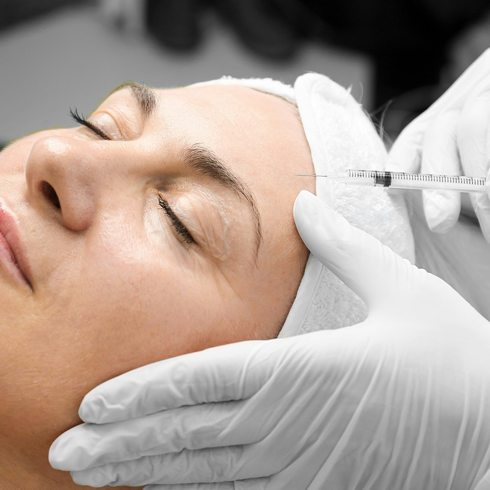 Woman receiving Botox injection after facelift surgery