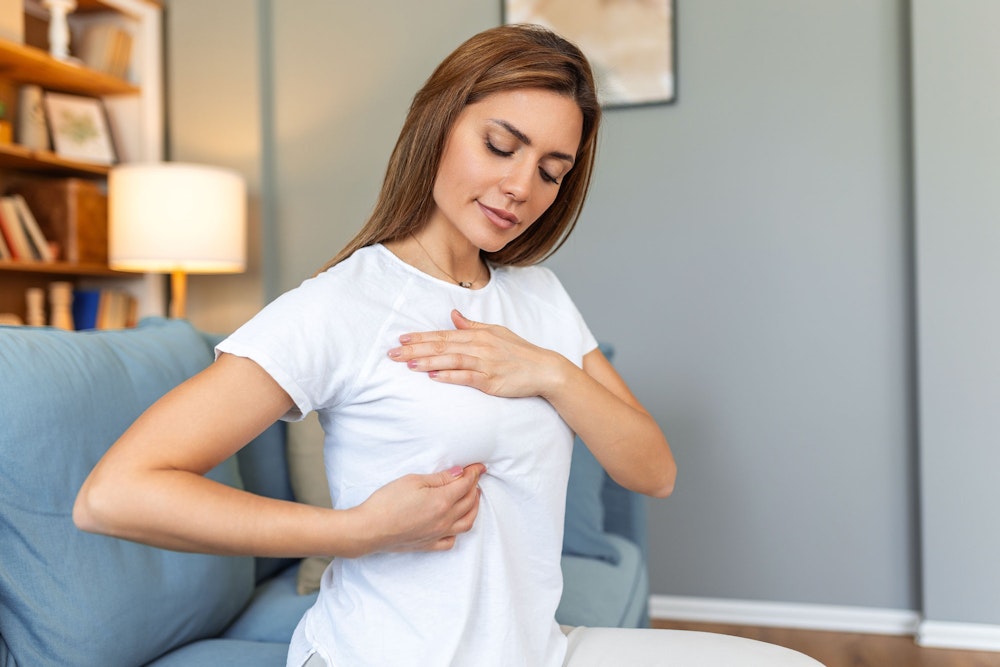 Woman after immediate reconstruction touching her chest