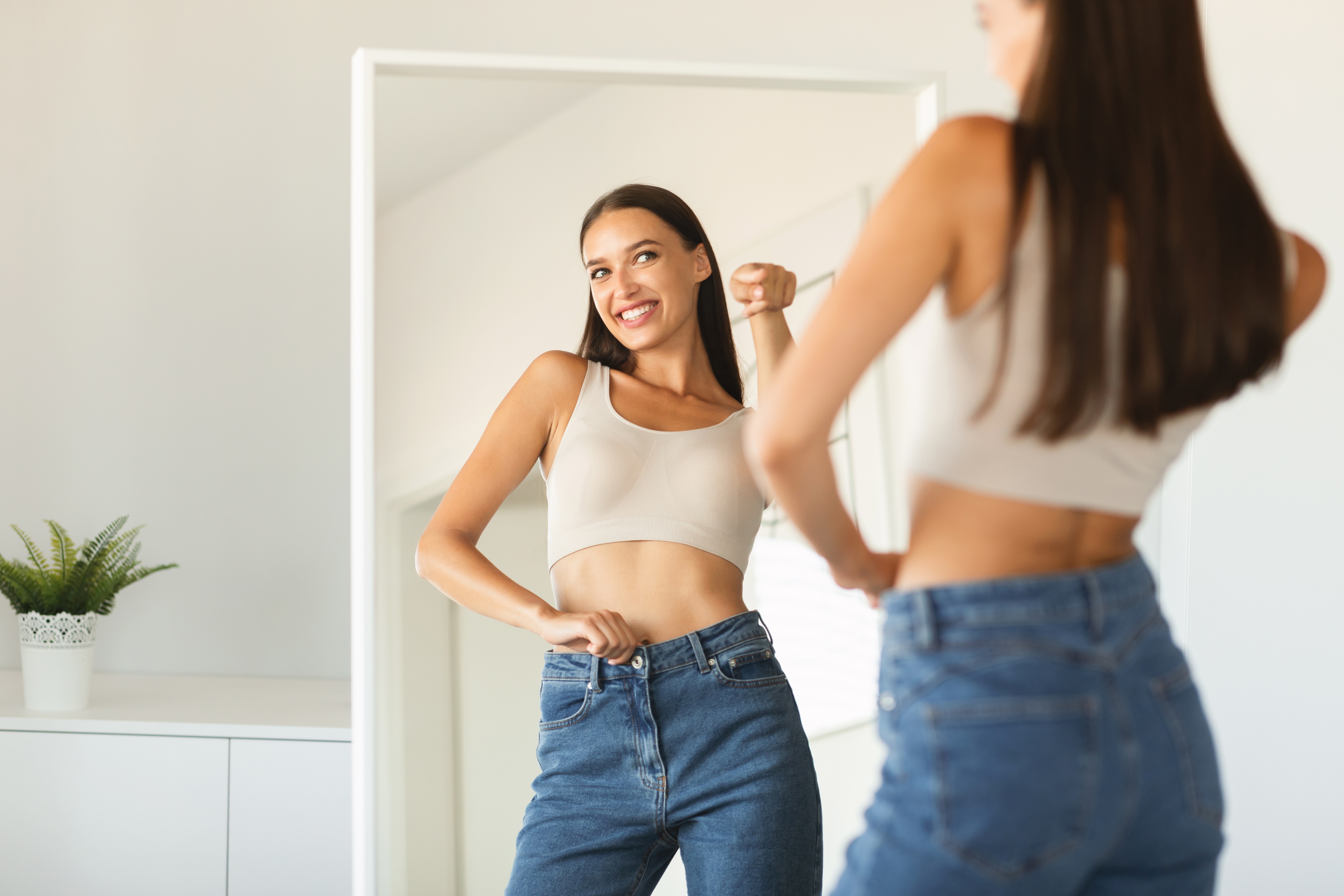 Woman admiring her figure in the mirror