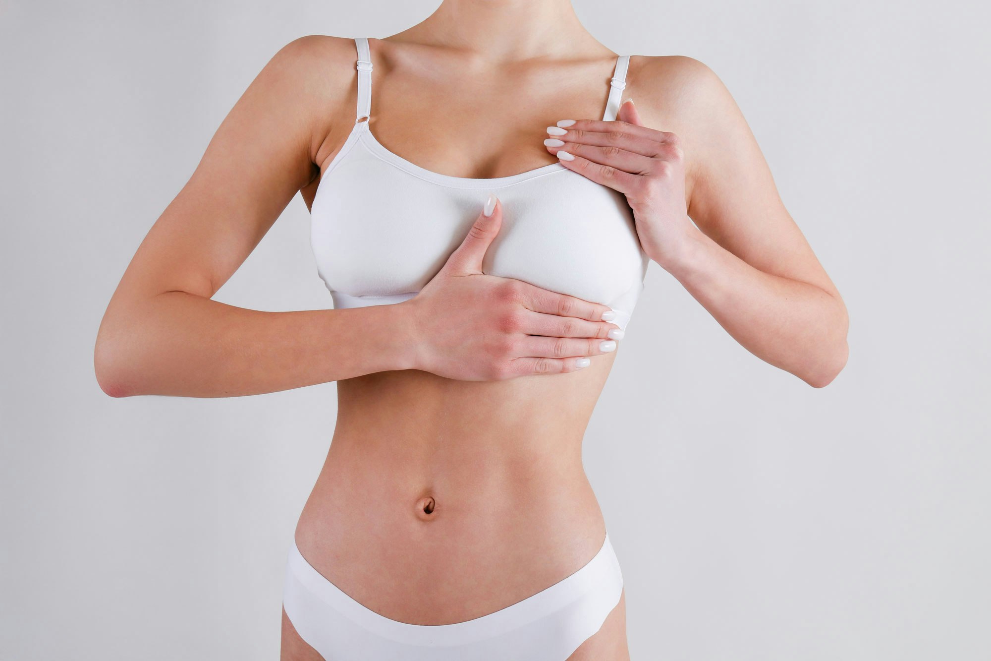 Woman touching chest after breast reconstruction