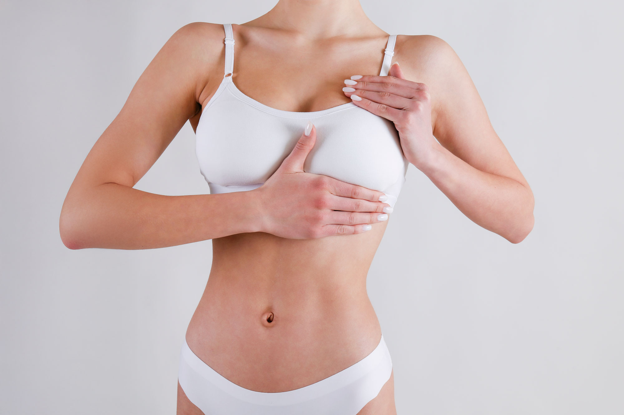 Woman touching chest after breast reconstruction