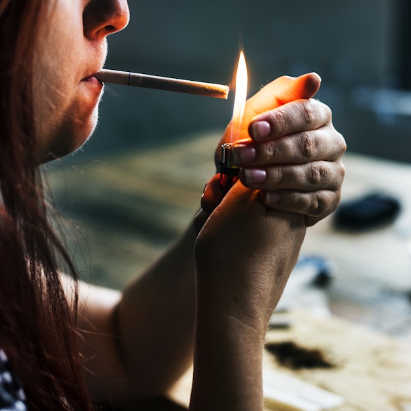 closeup of a woman lighting a cigarette