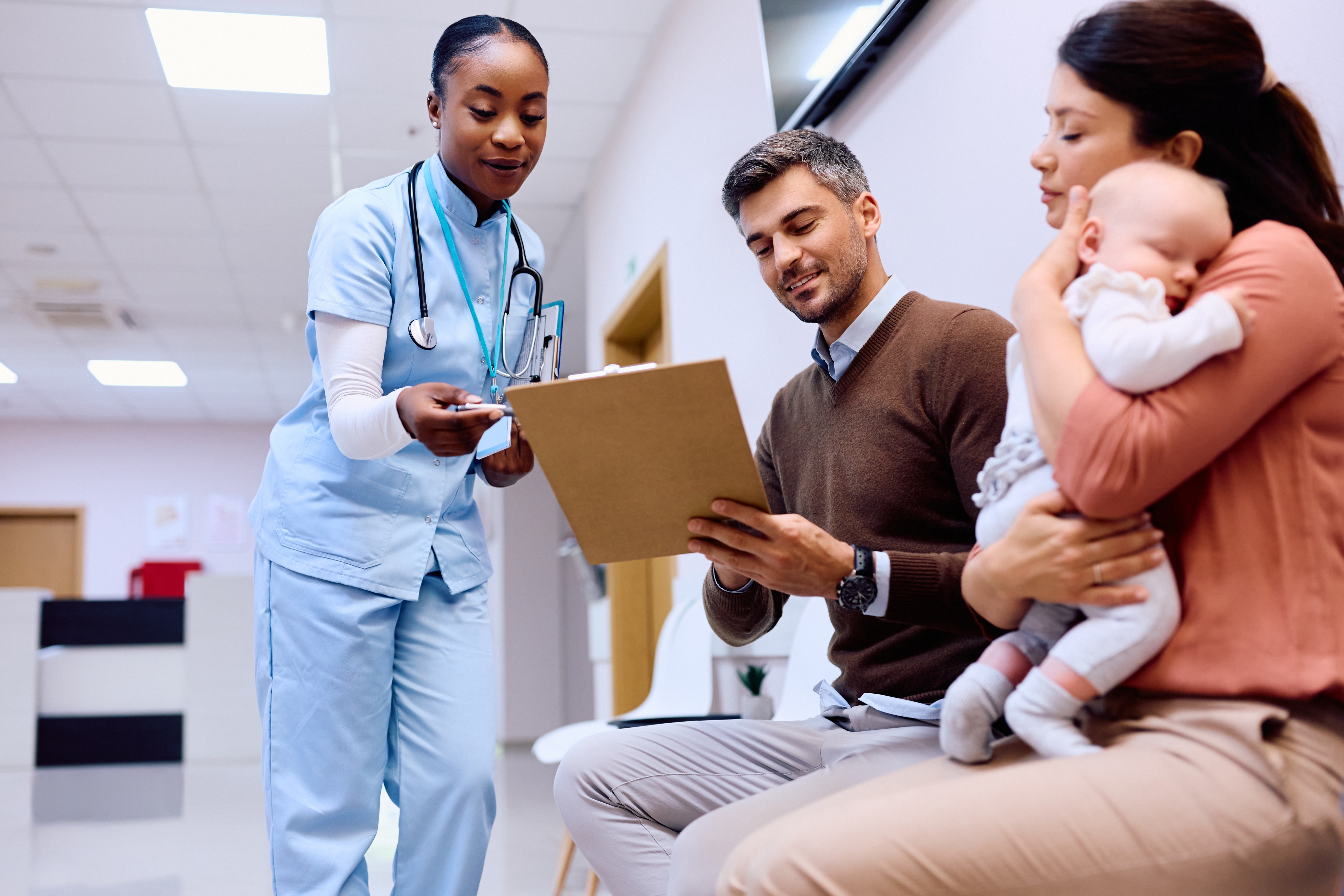 Parents with young child filling out a form
