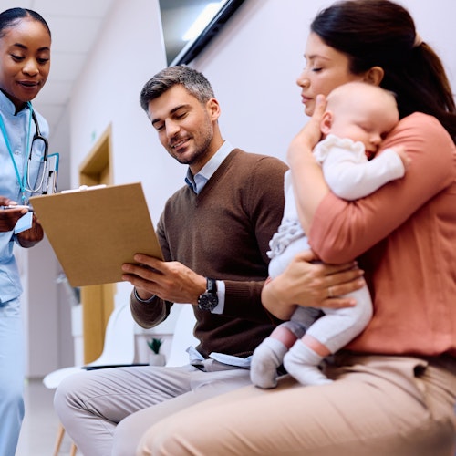 Parents with young child filling out a form