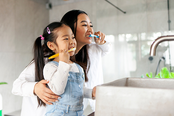 mother and daughter brushing teeth