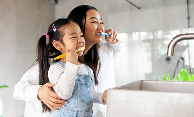 mother and daughter brushing teeth