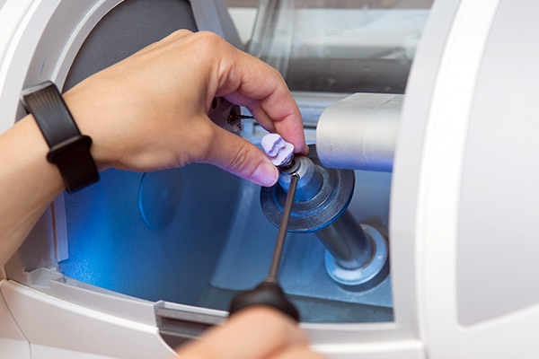 a dental crown being milled in a machine