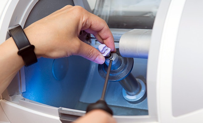 a dental crown being milled in a machine