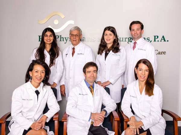 white haired woman holding hands and glasses to her face