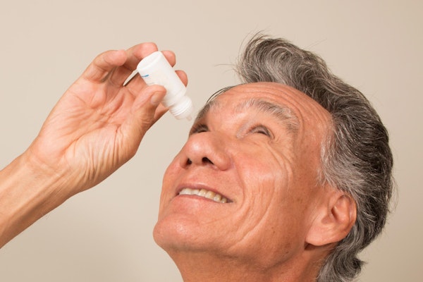 Mature man putting in eye drops