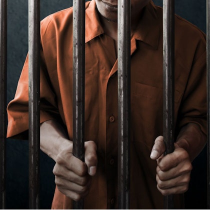 Hand gripping jail cell bars