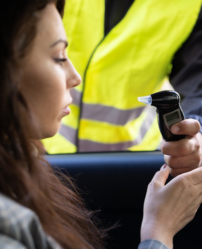 woman taking breathalyzer test