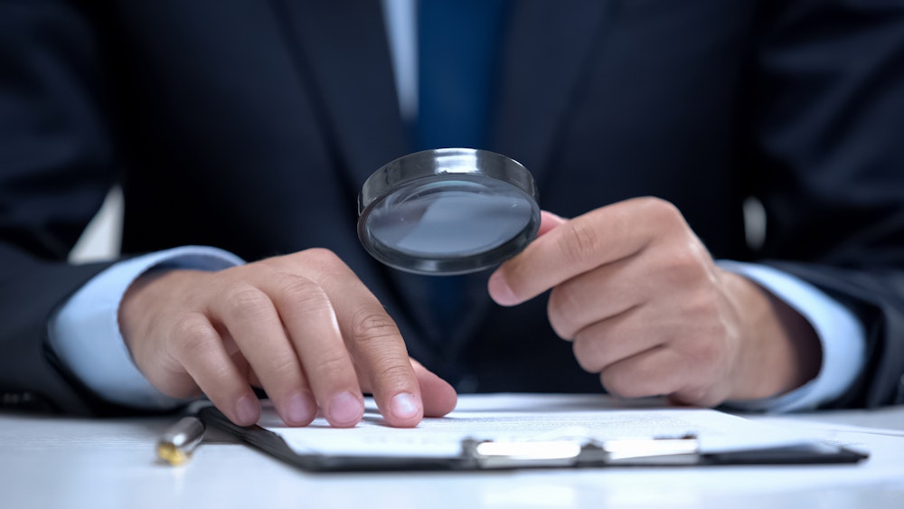 Lawyer looking at a case with a magnifying glass