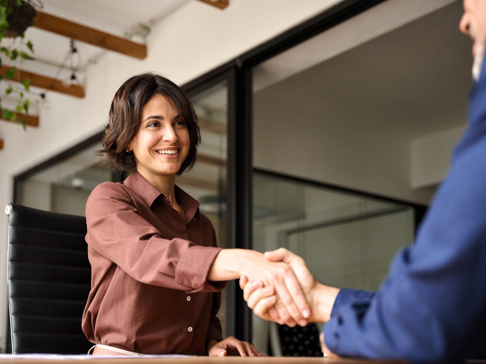 woman shaking hands across table