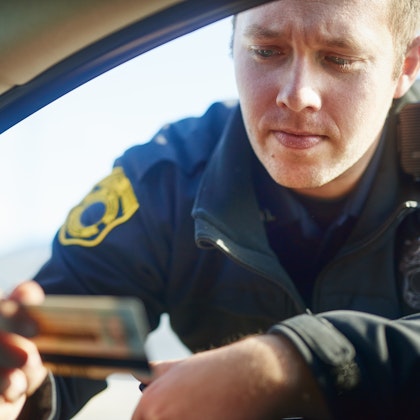 Cop looking at drivers license during stop