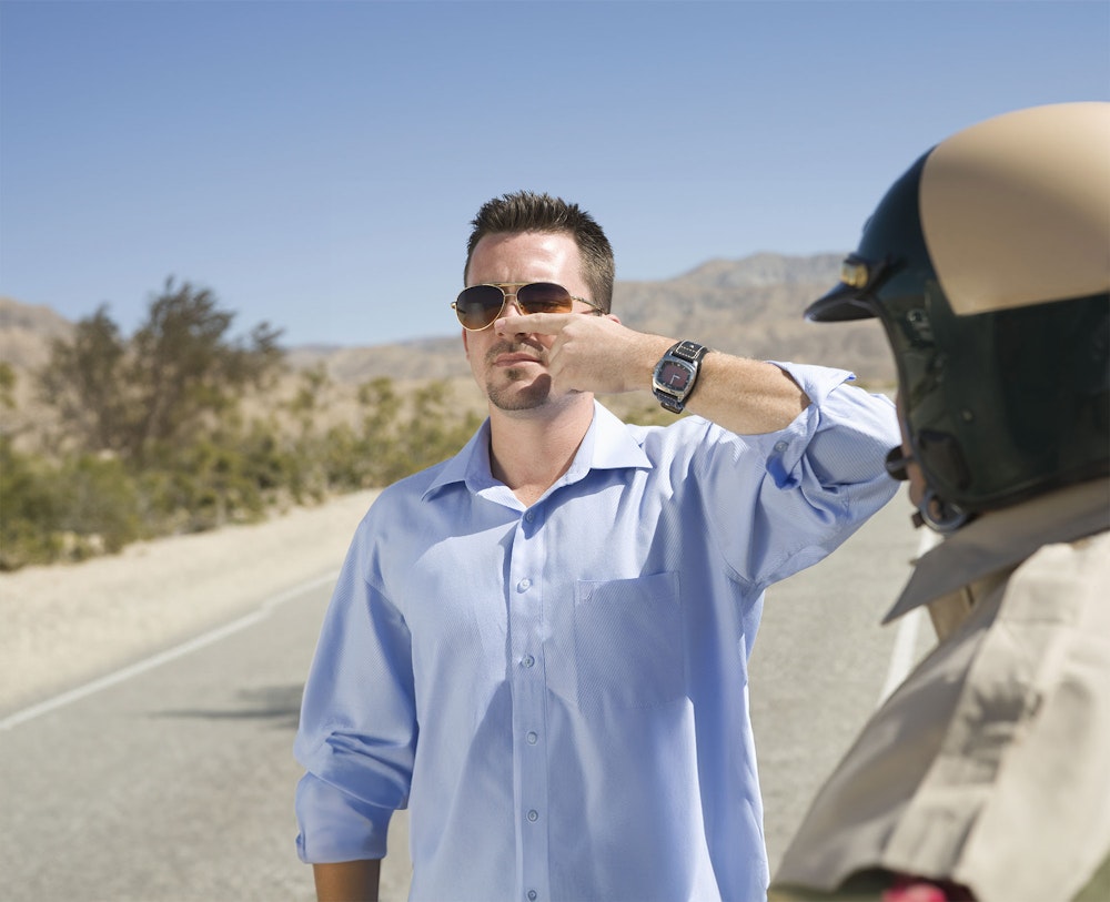 Man performing a field sobriety test in front of state trooper