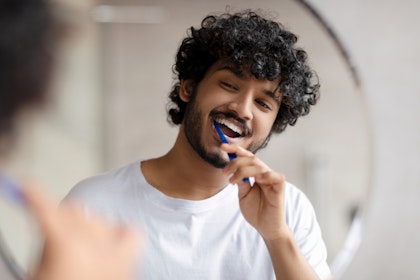 young man brushing his teeth