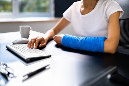 woman with cast using computer