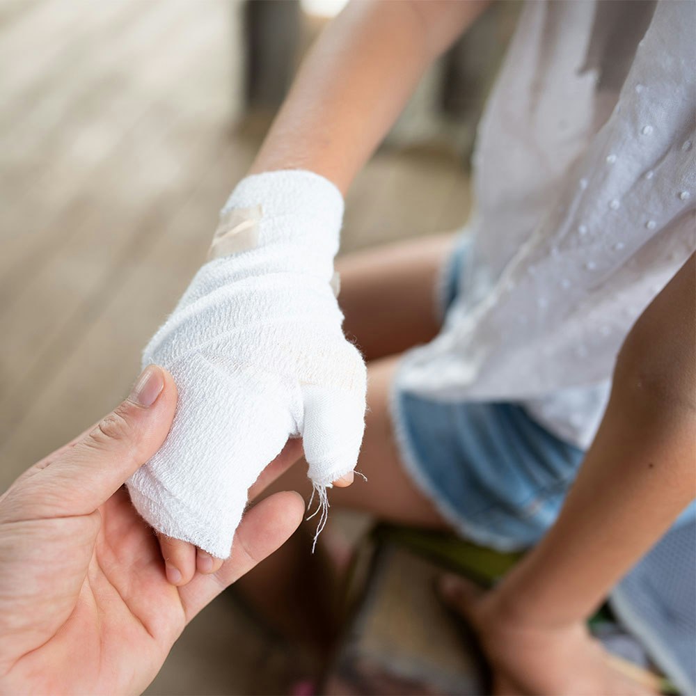 person holding a child's wrapped burnt hand