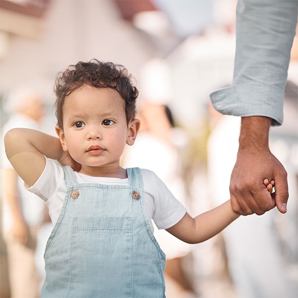 Young child holding hands with an adult
