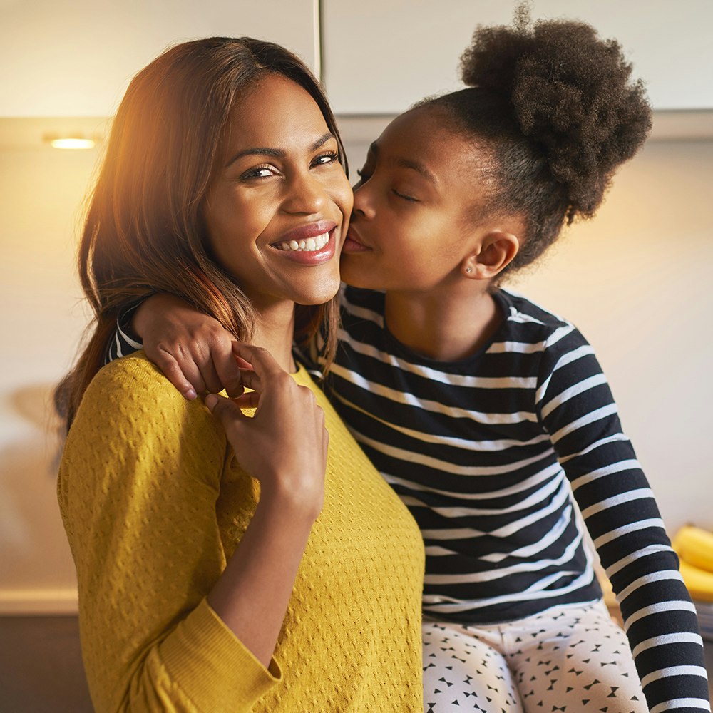 young girl and her mother kissing and hugging