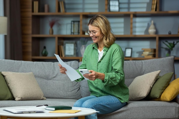 Woman looking at a living will and using her phone