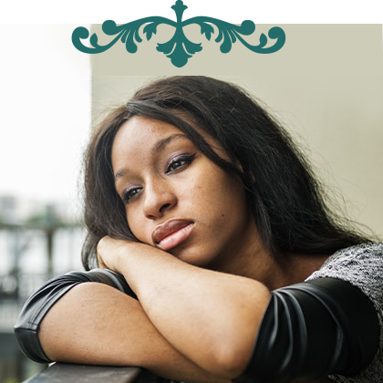 woman with sad expression looking out over a balcony