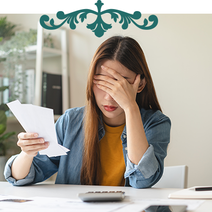 woman looking stressed with a pile of bills and paperwork
