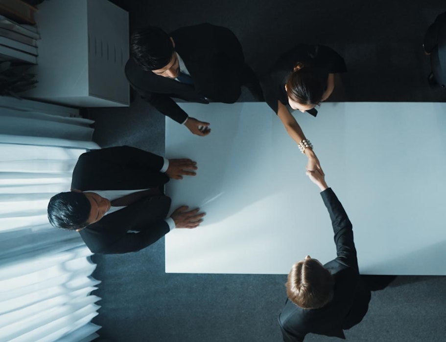 Separating couple shaking hands across table