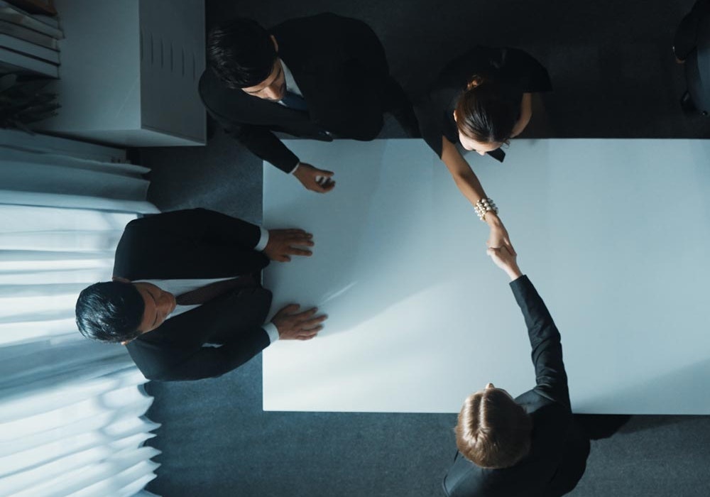 Separating couple shaking hands across table