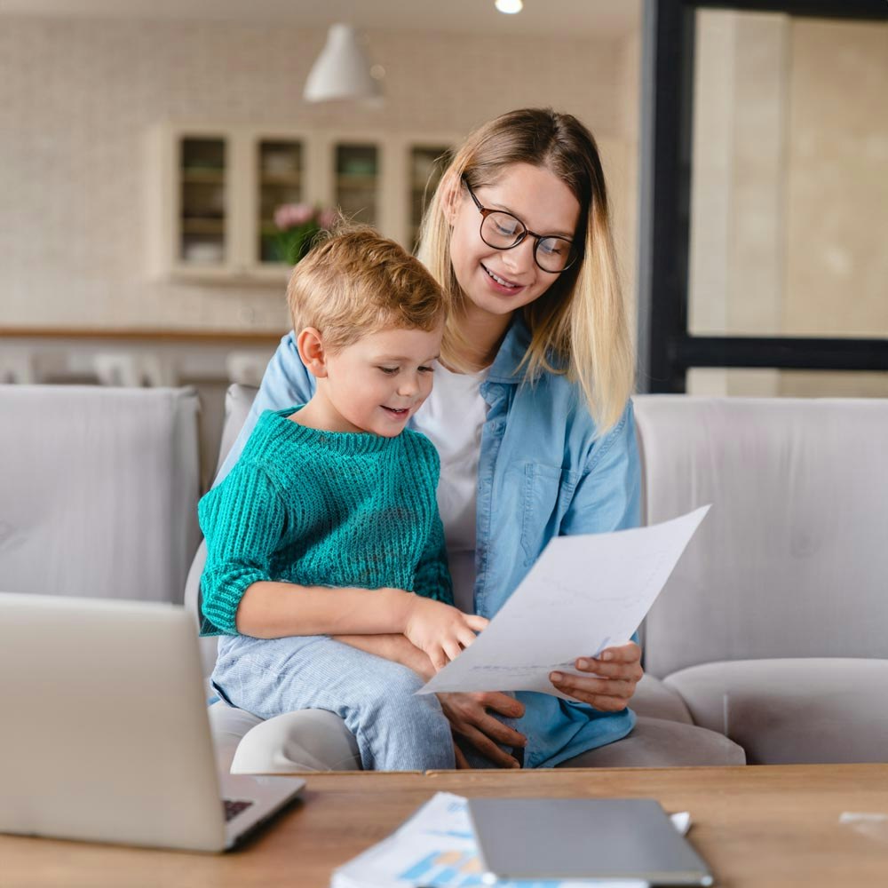 Mother reviewing paperwork with child on lap