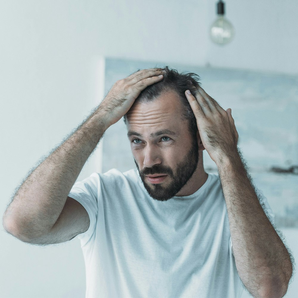 Man Checking Hair Density in Mirror