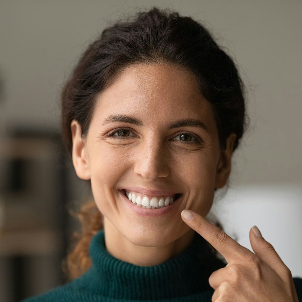woman pointing to her teeth