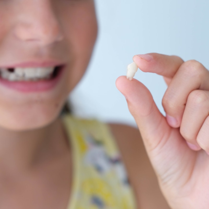 Child holding baby tooth