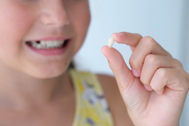 Child holding baby tooth