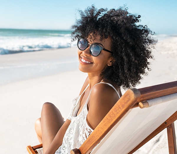 Smiling mommy makeover patient at the beach