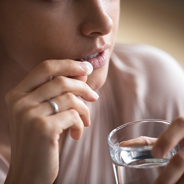 Woman putting pill in her mouth