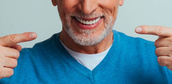 man pointing to whitened teeth